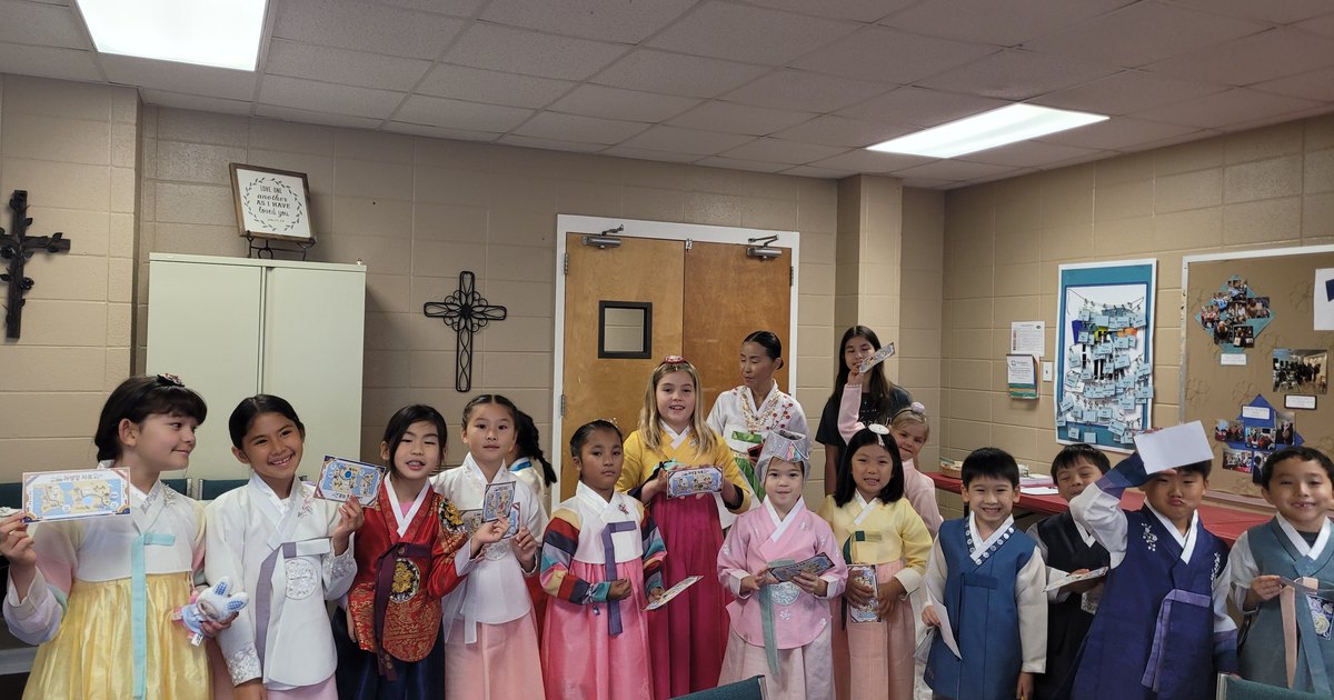 Students in hanbok holding up their completed homecoming tickets.