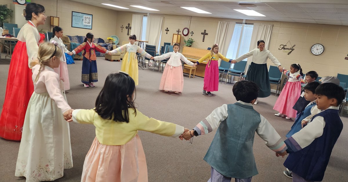 Students of the North Alabama Korean School in hanbok, holding hands in a circle for ganggangsullae at the Busan rest stop.