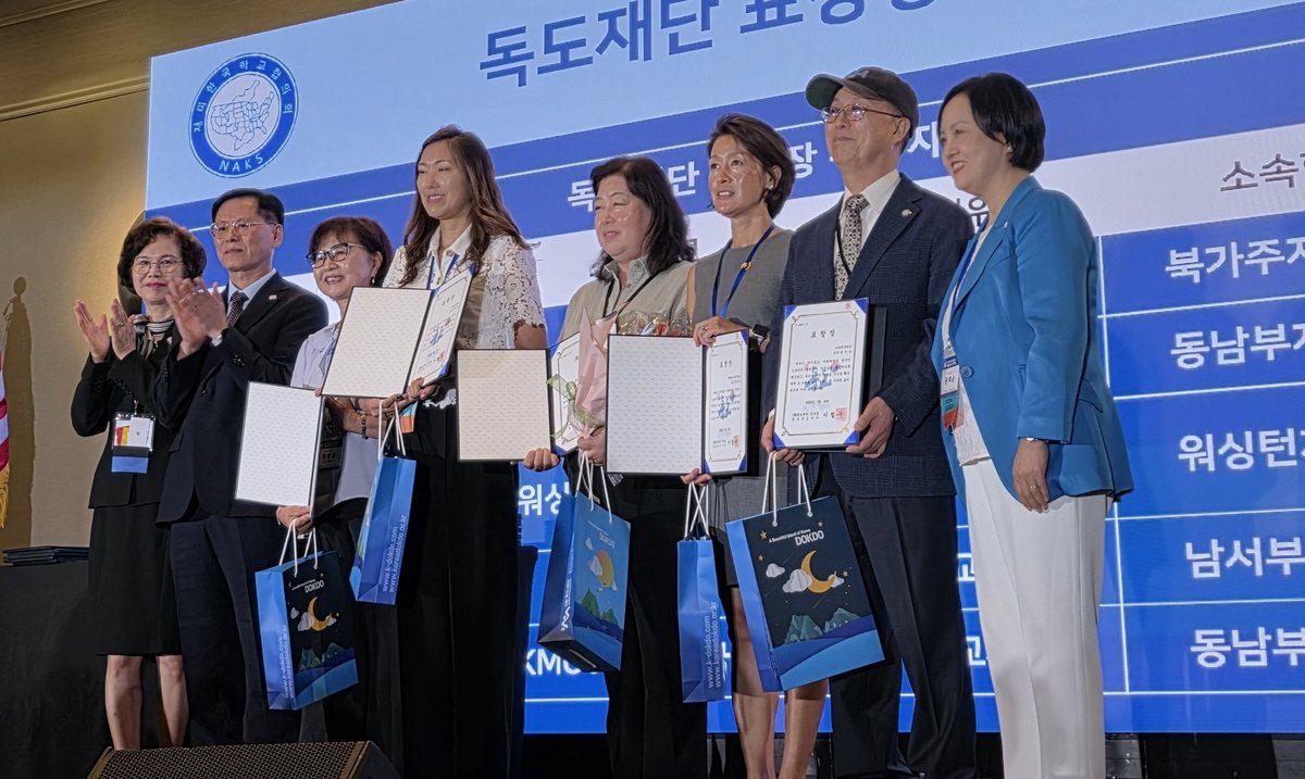 Recipients on stage holding Dokdo Foundation commendations at the 44th National Association for Korean Schools conference.
