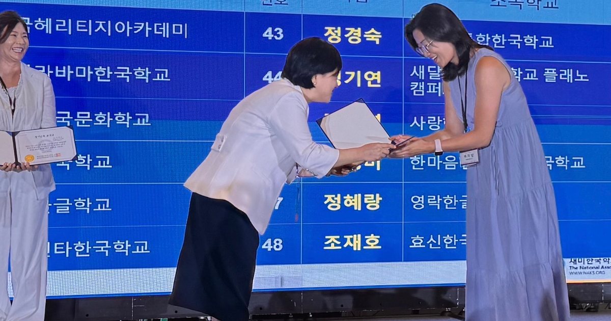 Lee Ji-na of the North Alabama Korean School receives a ten-year long-service teaching award on stage at the 44th National Association for Korean Schools conference.